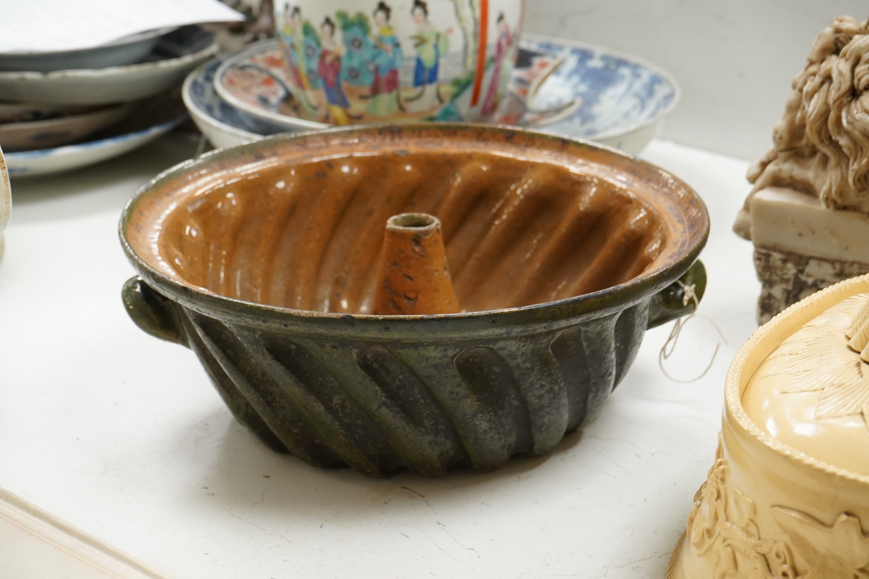 A 19th century oval caneware game/pie dish and cover, 24cm wide with an antique cake mould, (2)